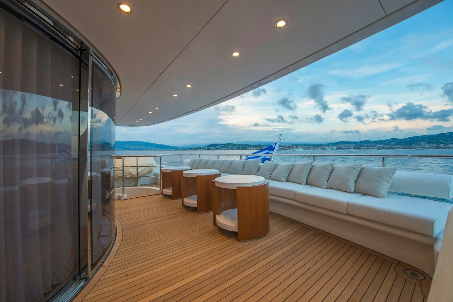 The broad sheltered aft terrace with seating extending around the stern